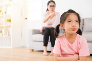 parent pointing at child with arms crossed