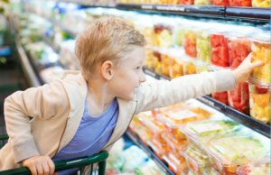 child reaching for fruit at grocery store