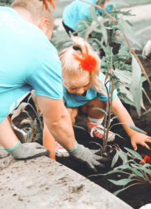 father and child pulling weeds