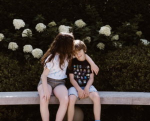 sister kissing brother on head 